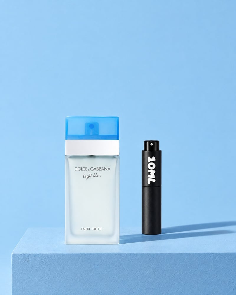 Light Blue di Dolce&Gabbana accanto a un atomizzatore da viaggio 10ML su un piedistallo blu