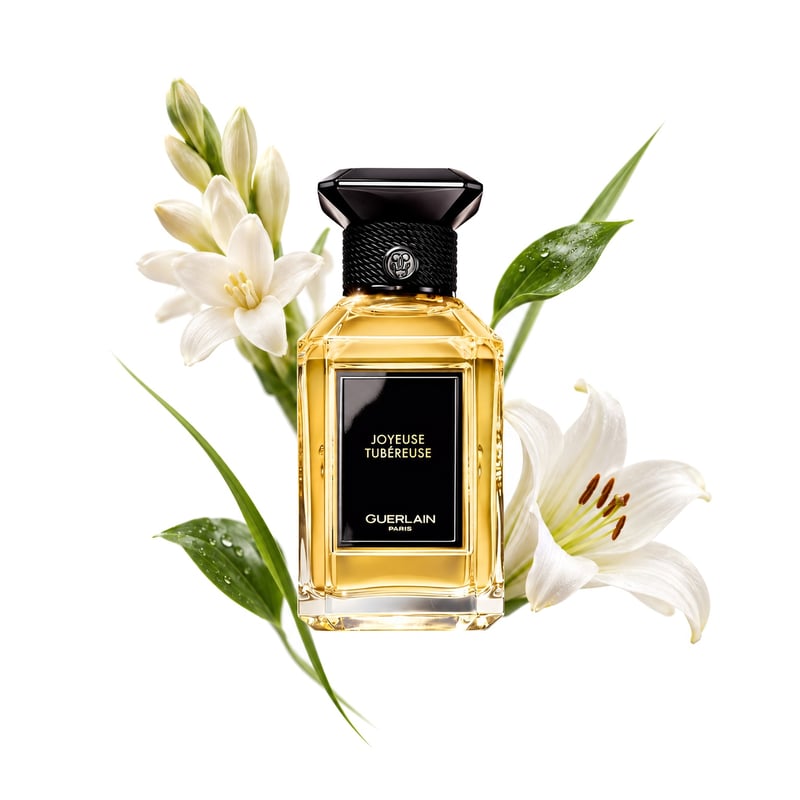 Joyeuse Tubéreuse by Guerlain, bottle pictured with its key notes: Green Notes, Tuberose and Lily