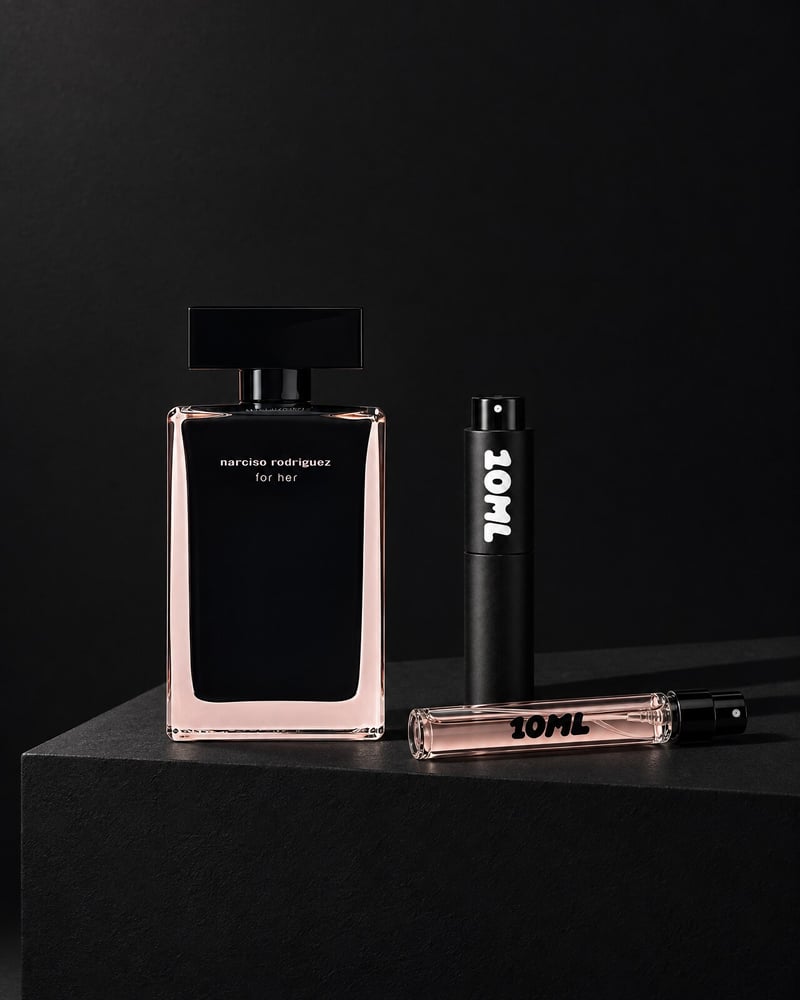 Narciso Rodriguez For Her with a 10ML travel atomiser and a 10ML refill vial on a black plinth